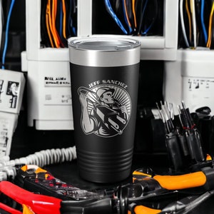May include: Black and silver stainless steel tumbler with a black and white graphic of an electrician holding a wire and the text "JEFF SANCHEZ".
