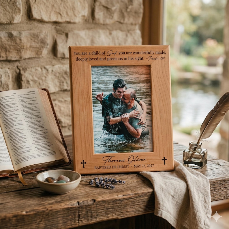 K&ouml;nnte beinhalten: Ein Bilderrahmen aus hellem Holz mit der Gravur 'You are a child of God you are wonderfully made, deeply loved and precious in his sight - Psalm 139' oben und 'Thomas Oliver BAPTIZED IN CHRIST MAY 23, 2027' am unteren Rand des Rahmens.