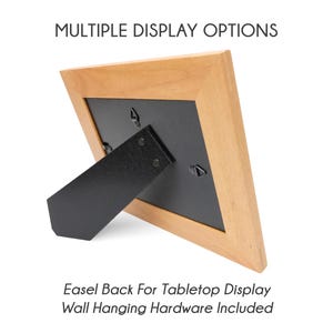 Pu&ograve; includere: Una cornice in legno marrone chiaro con retro nero e cavalletto per l'esposizione sul tavolo. La cornice ha molteplici opzioni di visualizzazione e include l'hardware per appenderla al muro. Il testo "MULTIPLE DISPLAY OPTIONS" e "Easel Back For Tabletop Display Wall Hanging Hardware Included" sono visibili.