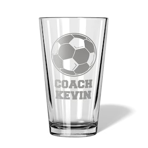 May include: A clear glass pint glass with a soccer ball and the text "COACH KEVIN" etched on the side.