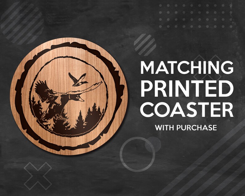 May include: A wooden coaster with a laser-engraved design of two flying ducks in a forest setting. The coaster is round and has a natural wood finish. The text "MATCHING PRINTED COASTER WITH PURCHASE" is displayed on a black background.