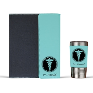 K&ouml;nnte beinhalten: Ein personalisiertes Notizbuch- und Becher-Set in Tealblau und Schwarz mit einem medizinischen Caduceus-Symbol und dem Namen "Dr. Hamid".