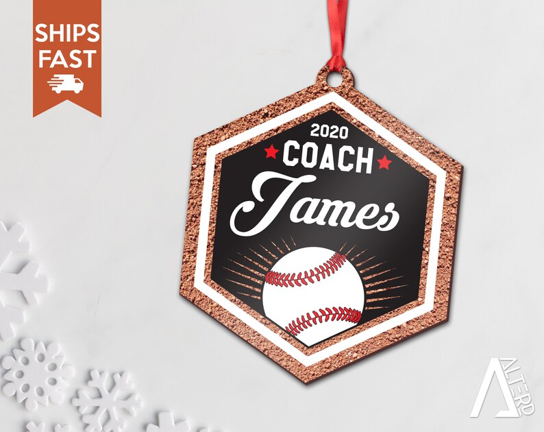 May include: A hexagonal baseball-themed Christmas ornament with a red and white baseball, gold glitter, and the text "2020 COACH James" in black.