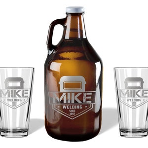 May include: A brown glass growler with a white cap and handle, flanked by two clear pint glasses. All items feature a gray welding mask graphic and the text "MIKE WELDING SINCE 1997".