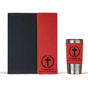 May include: A red and black leather journal with a cross and the text "2 Timothy 4:2 Pastor Tracy W. Wilson" on the front cover. A red and silver travel mug with a cross and the text "2 Timothy 4:2 Pastor Tracy W. Wilson" on the side.