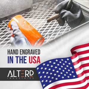 May include: An orange glass with a white logo is being hand engraved. The image includes the text "HAND ENGRAVED IN THE USA" and the "ALTERD INDUSTRIES" logo. An American flag is in the background.