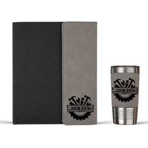 May include: A gray faux leather journal with a black faux leather cover and a matching gray faux leather tumbler with a black logo that says "JOHN RICH" with a saw blade and tools around the text.