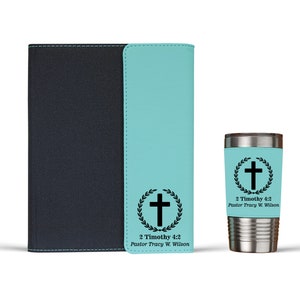 May include: A teal blue journal with a black leather cover and a matching teal blue tumbler with a black cross and laurel wreath design. The text "2 Timothy 4:2 Pastor Tracy W. Wilson" is printed on both items.