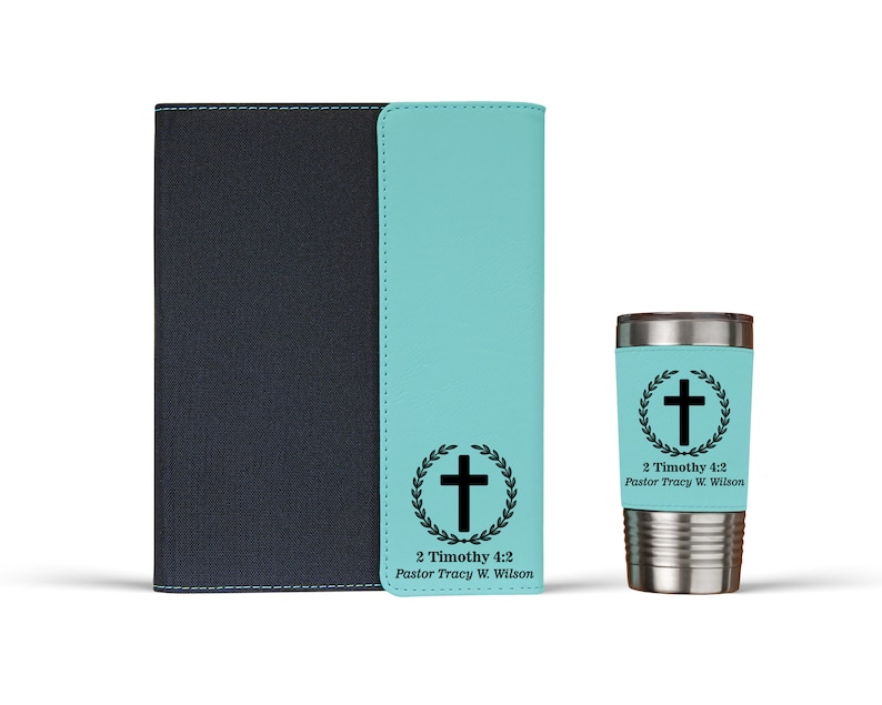 May include: A teal blue journal with a black leather cover and a matching teal blue tumbler with a black cross and laurel wreath design. The text "2 Timothy 4:2 Pastor Tracy W. Wilson" is printed on both items.