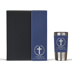 May include: A set of three personalized gifts featuring a cross and laurel wreath design. The set includes a blue leather journal, a matching blue leather phone case, and a stainless steel tumbler with a blue leather wrap. The text on the items reads "2 Timothy 4:2 Pastor Tracy W. Wilson".