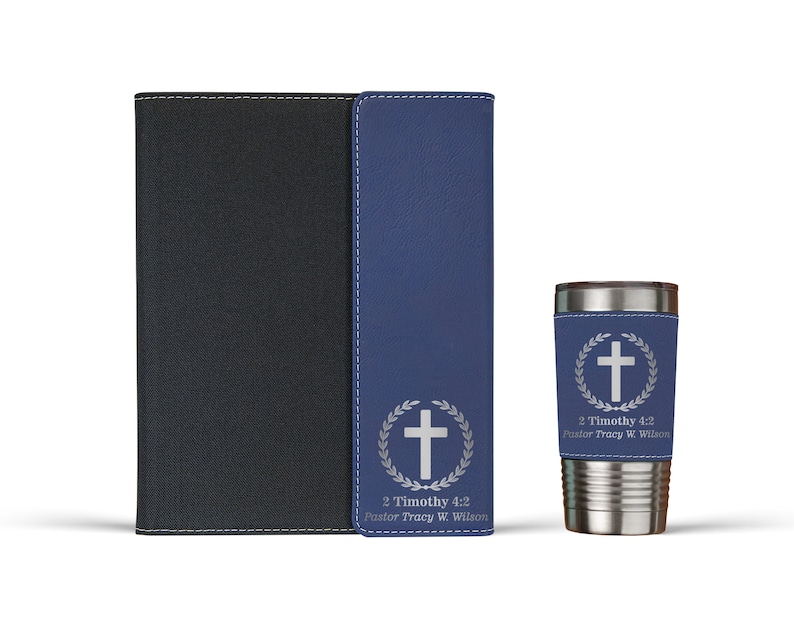 May include: A set of three personalized gifts featuring a cross and laurel wreath design. The set includes a blue leather journal, a matching blue leather phone case, and a stainless steel tumbler with a blue leather wrap. The text on the items reads "2 Timothy 4:2 Pastor Tracy W. Wilson".
