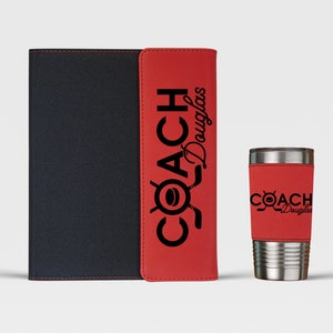 May include: A red and black leatherette notebook and a red and silver tumbler with the text "COACH Douglas" printed on both items.