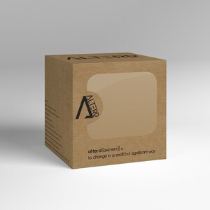 May include: A brown cardboard box with a clear window on the front. The box has the word "ALTERD" printed on the front in black letters. The text below the logo reads "alter-d [awl-ter-d] v to change in a small but significant way."