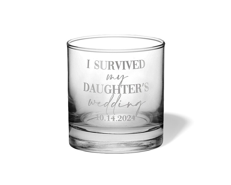 May include: A clear glass tumbler featuring the etched text I SURVIVED my DAUGHTER'S wedding and the date 10.14.2024. The vessel has a thick base and straight sides, with the white lettering clearly visible against the transparent glass surface.