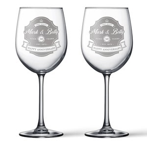 May include: Two clear glass wine glasses with etched designs. Each glass has a banner with the text "Mark & Betty" and "Happy Anniversary". The banner also includes the text "Aged 50 Years" and "Est 1972".