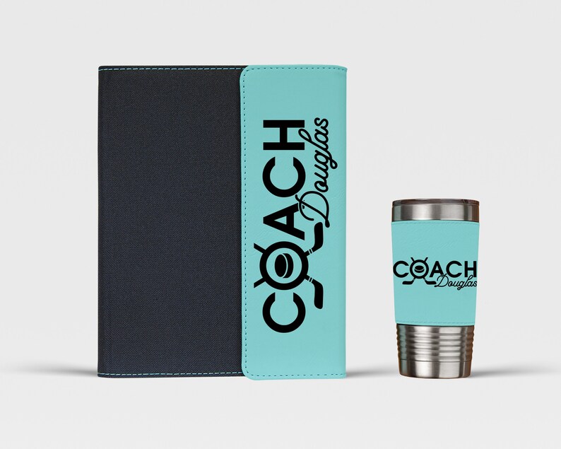 May include: A black and blue personalized notebook and a stainless steel tumbler with a blue and black design. The notebook and tumbler both have the text "COACH Douglas" printed on them.