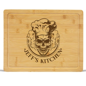 May include: A brown bamboo cutting board with a skull wearing a chef's hat and the text "Jeff's Kitchen" engraved on the surface.