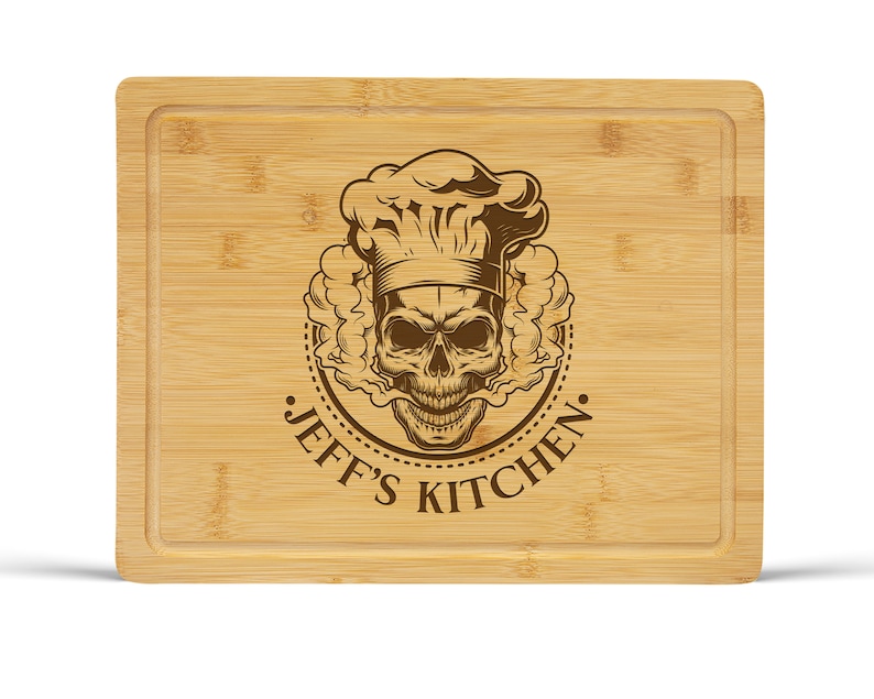May include: A brown bamboo cutting board with a skull wearing a chef's hat and the text "Jeff's Kitchen" engraved on the surface.