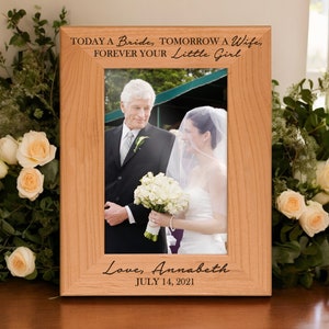 May include: Wooden picture frame with a wedding photo. The frame has the text "TODAY A Bride, TOMORROW A Wife, FOREVER YOUR Little Girl" and "Love, Annabeth JULY 14, 2021". The photo shows a bride and her father.
