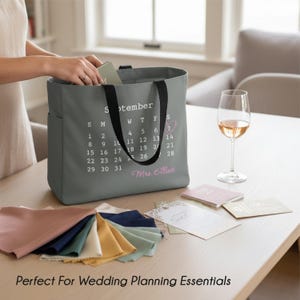 May include: A white ceramic mug with a black handle and the text "But First, Coffee" in a black, handwritten-style font. The mug is on a white surface.