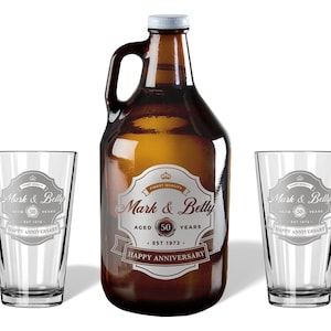 May include: A 64-ounce glass growler with a brown glass bottle and two matching pint glasses. The growler and glasses are engraved with the text "Mark & Betty Aged 50 Years Est 1972 Happy Anniversary".
