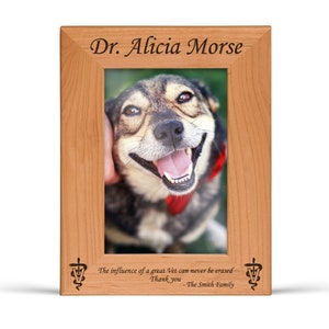 May include: A wooden picture frame with a personalised inscription for Dr. Alicia Morse. The frame features a photo of a dog and the text "The influence of a great Vet can never be erased. Thank you - The Smith Family."