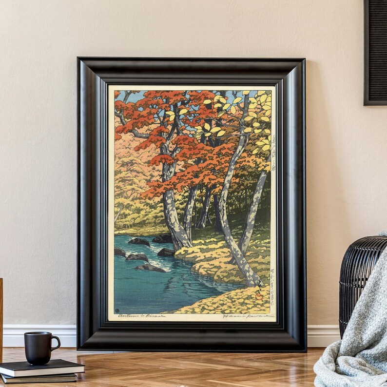 May include: A framed print of a Japanese woodblock print depicting a stream flowing through a forest with red, yellow, and green trees. The print is titled "Autumn in Kiso" and signed by the artist.