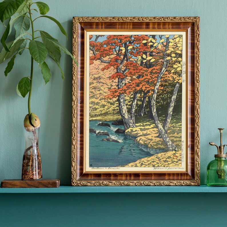 May include: A framed wood print of a Japanese landscape with a river and trees in autumn colors. The print is titled "Autumn in Japan".