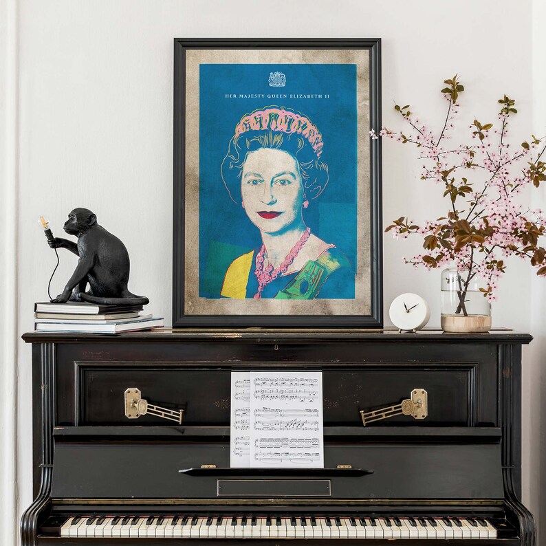 May include: A black and white framed print of Queen Elizabeth II in a pop art style. The print is on a black piano with sheet music on top. The print has the text "HER MAJESTY QUEEN ELIZABETH II" at the top.