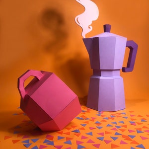 May include: A purple paper coffee pot with a white paper steam design above it. A pink paper container with a handle is on the left side of the image. The objects are on an orange surface with scattered blue, pink, and orange paper triangles.