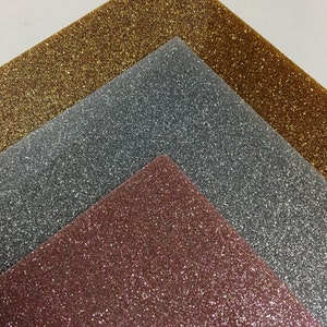 Puede incluir: Tres hojas de papel de purpurina en oro rosa, plata y oro. Las hojas est&aacute;n apiladas una encima de la otra, con la hoja de oro rosa en la parte inferior, la hoja de plata en el medio y la hoja de oro en la parte superior.