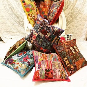 May include: A collection of colourful patchwork cushion covers with intricate embroidery. The cushions are made from a variety of fabrics and feature different patterns and designs.