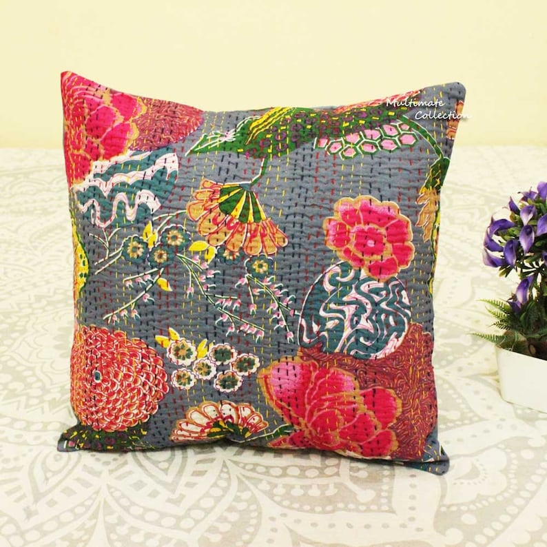 May include: A gray cotton pillow cover with a floral pattern in shades of pink, red, yellow, green, and blue. The pillow cover is quilted and has a subtle texture. The text "Mudlomare Collection" is visible in the upper right corner of the image.