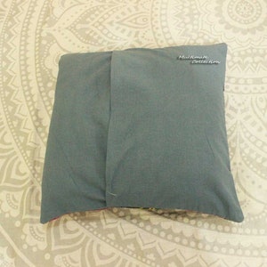 May include: The back of a gray pillow with a zipper closure. The pillow has a label that says "Multimate Collection".