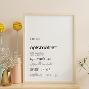 May include: A framed print with the text "i am an: optometrist" in black and the word "optometrist" in gray. The text is written in multiple languages, including English, Chinese, French, Arabic, Spanish, and Greek.