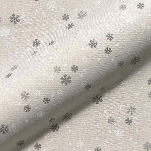 May include: A beige fabric with a repeating pattern of snowflakes and stars in white and gray. The snowflakes are detailed with six points, and the stars have five points. The fabric has a textured appearance.