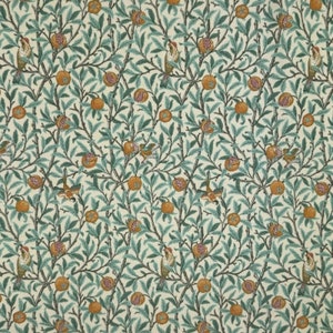 May include: A patterned fabric featuring a design of birds, pomegranates, and foliage. The pattern includes orange pomegranates, green leaves, and birds with red and yellow details. The background is cream, and the branches are brown.