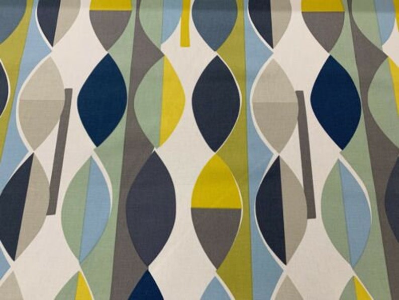 May include: Fabric with a repeating abstract pattern of leaf-like shapes in navy blue, yellow, grey, light blue, and white. The design has a modern, geometric style. The fabric would be suitable for upholstery or soft furnishings.