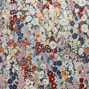Può includere: Primo piano di un arazzo floreale con un fitto motivo di fiori colorati. I fiori sono in tonalità di rosso, blu, giallo, rosa e bianco, creando una superficie vibrante e strutturata. L'effetto complessivo ricorda un prato in fiore.