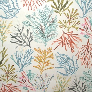 Peut inclure: Un tissu avec un motif répété de motifs d'algues colorées. Les algues sont dans des tons de bleu, vert, orange et jaune sur un fond blanc. Le motif évoque une scène sous-marine.