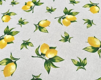 May include: A light gray fabric featuring a repeating pattern of bright yellow lemons with green leaves. The lemons are depicted in various clusters and individual placements across the textile surface, showcasing a consistent botanical print design.