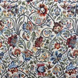 Può includere: Primo piano di un arazzo floreale con sfondo color crema. Il design presenta intricati motivi di fiori nelle tonalità del rosso, blu e arancione, intrecciati con foglie verdi e tralci grigio scuro. Anche piccoli uccelli sono incorporati nel design.