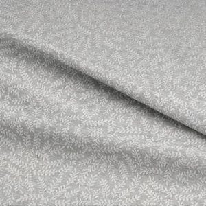 May include: A close-up of grey fabric with a repeating white leaf pattern. The fabric is folded, showing depth and texture. The design is delicate and creates a subtle, natural aesthetic, suitable for various textile projects.