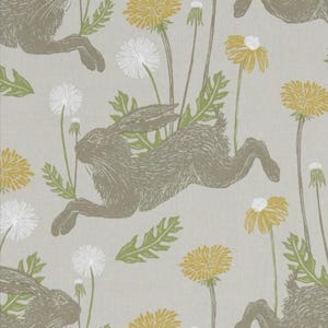 Può includere: Motivo ripetuto con lepri in corsa, denti di leone e fogliame in tonalità di grigio, giallo e verde su sfondo grigio chiaro. Il design ha un'estetica rustica e disegnata a mano, adatta per tessuto o carta da parati.