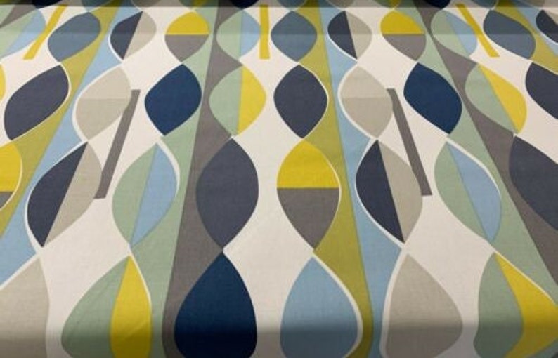 May include: A fabric with a repeating abstract pattern. The design features elongated, leaf-like shapes in shades of blue, yellow, grey, and green against a white background. The pattern has a mid-century modern aesthetic.