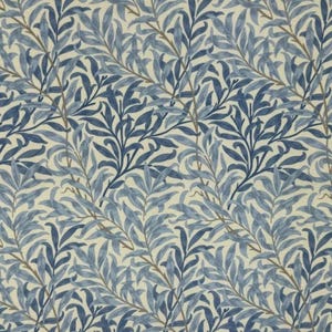 Peut inclure: Un tissu avec un motif répété de feuilles et de branches stylisées bleues et bleu clair sur un fond crème. Les feuilles ont un aspect détaillé et texturé, créant un thème botanique naturel.