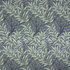 May include: A repeating pattern of stylized willow branches and leaves in shades of green and grey against a muted blue background. The design has a textured appearance, suggesting a fabric or wallpaper.