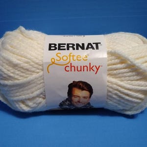 May include: A skein of Bernat Softee Chunky yarn in a white color. The yarn is a soft, chunky yarn that is perfect for knitting or crocheting.
