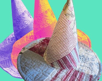 May include: A conical hat constructed from quilted fabric patches featuring various patterns including stripes, floral prints, and geometric designs in shades of red, blue, white, and beige. The hat has a wide, circular brim and a pointed crown.