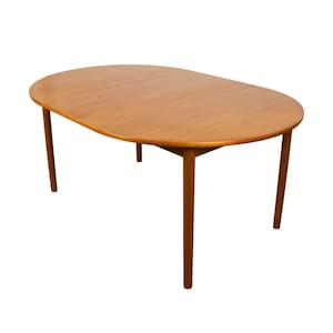 May include: A light brown wooden dining table with an oval-shaped top and four tapered legs. The table features a smooth, polished surface with a visible wood grain pattern and a central seam indicating an extendable design mechanism.